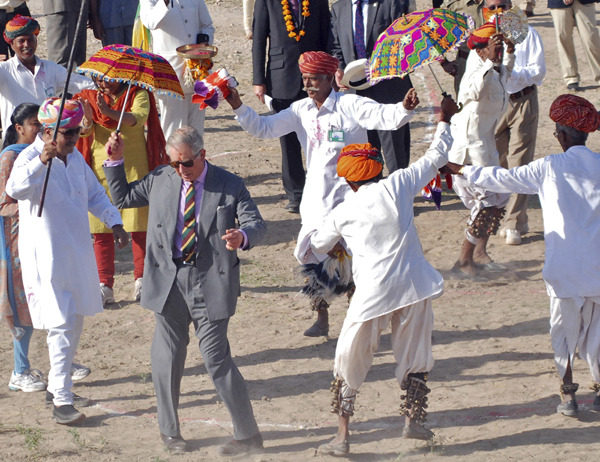 Britain’s Prince Charles dances with villagers at Tolasar village