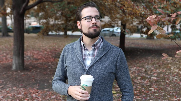 Mr. Autumn Man Walking Down Street With Cup Of Coffee, Wearing Sweater Over Plaid Collared Shirt