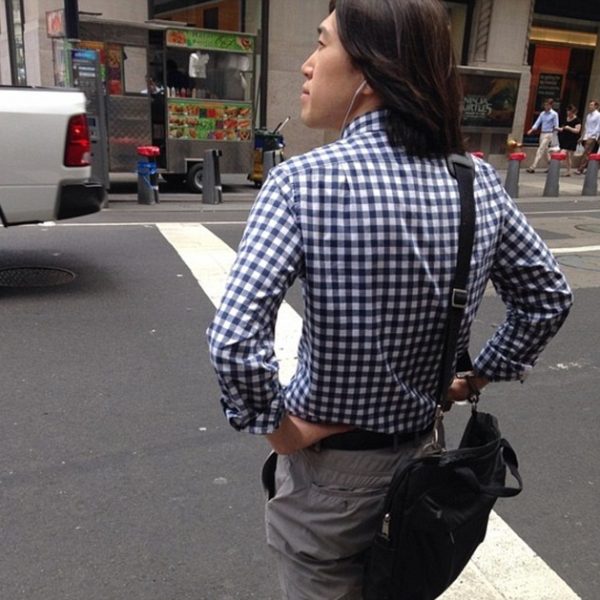 Spring Man Walking Down Street with Shoulder Bag, Wearing Gingham Shirt and Flat Front Chinos